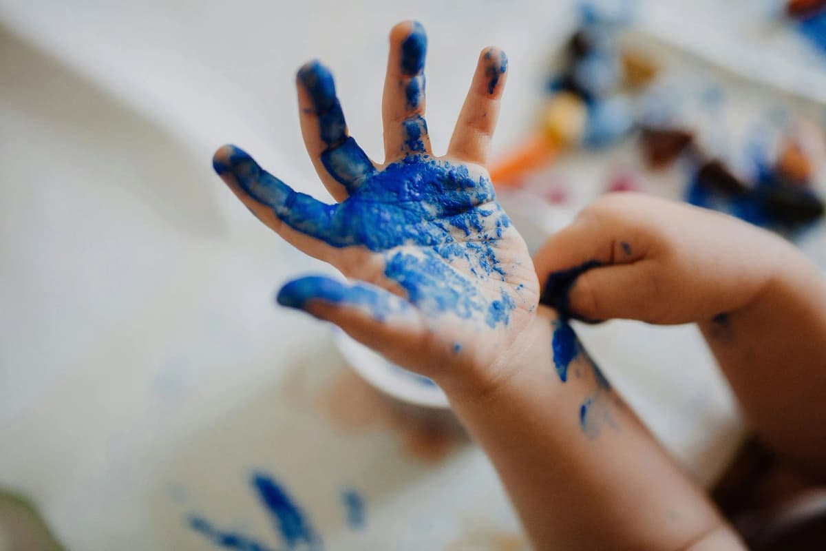 Child's hand covered in blue paint